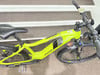 Ein grünes Genesis E-Pro E-Bike steht auf Stufen, Vorderansicht.
