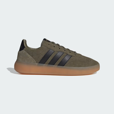Zelené tenisky Adidas s černými pruhy a hnědou podrážkou.