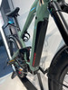 Grünes E-Bike mit Federung und schwarzem Akku am Rahmen.