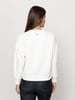 Női fehér pulóver textúrával és logóval a hátán.