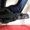 Nahaufnahme von Kurbel und Pedal eines dunkelblauen E-Bikes.