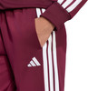 Burgunderrote Adidas Jogginghose mit weißen Streifen und Logo.