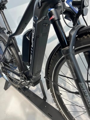 Ein schwarzes E-Bike mit Mittelmotor und großem Akku am Rahmen. Ein schwarzes E-Bike mit Mittelmotor und großem Akku am Rahmen.