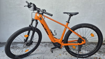 Orange Mountain E-Bike mit schwarzen Rädern und Federung. Orange Mountain E-Bike mit schwarzen Rädern und Federung.