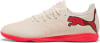 Beige Puma Fußballschuhe mit rosa Streifen und Logo.
