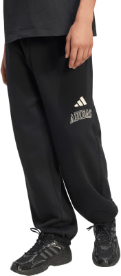 Schwarze Adidas Jogginghose mit Logo auf dem Oberschenkel und schwarzen Turnschuhen. Schwarze Adidas Jogginghose mit Logo auf dem Oberschenkel und schwarzen Turnschuhen.