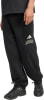 Schwarze Adidas Jogginghose mit Logo auf dem Oberschenkel und schwarzen Turnschuhen.