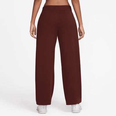 Damen-Latzhose in Braun mit weißem Sneaker. Damen-Latzhose in Braun mit weißem Sneaker.