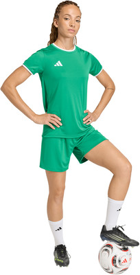 Frau im grünen Fußballtrikot und Shorts mit Ball. Frau im grünen Fußballtrikot und Shorts mit Ball.