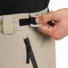 Ein Mann schließt einen Klettverschluss an einer Hose neben einer Reißverschlusstasche.
