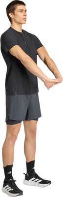 Ein Mann in schwarzem T-Shirt und grauer Hose dehnt seine Arme. Ein Mann in schwarzem T-Shirt und grauer Hose dehnt seine Arme.