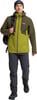 Ein Mann in einer grünen Jacke und dunkler Hose mit Rucksack.