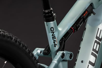 Detail des Mountainbike-Hinterbaus mit Dämpfer und ONE44-Schriftzug. Detail des Mountainbike-Hinterbaus mit Dämpfer und ONE44-Schriftzug.