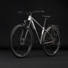 Silbernes Fahrrad mit schwarzen Details und Schutzblechen vor schwarzem Hintergrund.