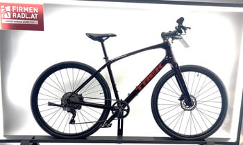 Ein rotes Trek-Fahrrad auf einem schwarzen Ständer mit Firmenlogo