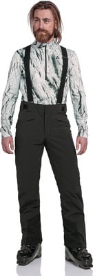 Ein Mann in Skibekleidung mit Muster, schwarzer Hose und Skischuhen. Ein Mann in Skibekleidung mit Muster, schwarzer Hose und Skischuhen.