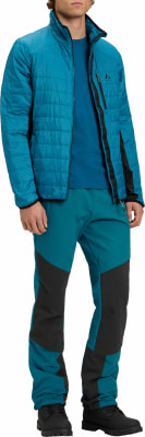 Mann in blauer Steppjacke und tealfarbener Hose mit schwarzen Einsätzen. Mann in blauer Steppjacke und tealfarbener Hose mit schwarzen Einsätzen.