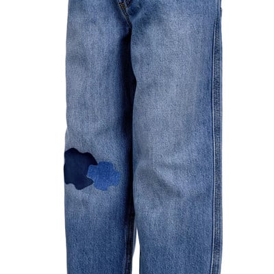 Jeans mit blauen Flicken am linken Hosenbein. Jeans mit blauen Flicken am linken Hosenbein.