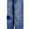 Jeans mit blauen Flicken am linken Hosenbein.