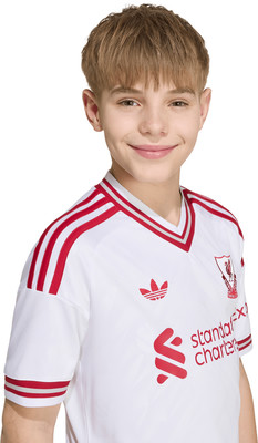 Junge in weißem Fußballtrikot mit roten Streifen und Logos Junge in weißem Fußballtrikot mit roten Streifen und Logos