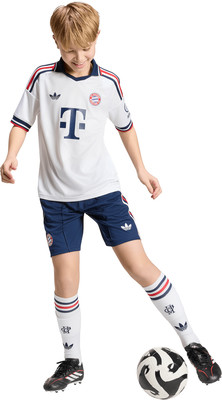Ein Junge im Fußballtrikot und Shorts mit einem Ball am Fuß. Ein Junge im Fußballtrikot und Shorts mit einem Ball am Fuß.