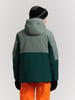 Rückansicht eines Mannes in einer Winterjacke und orangefarbener Hose.
