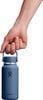 Eine Hand hält eine blaue Hydro Flask Flasche am Griff.