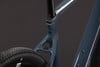 Detail eines Fahrradrahmens mit Carbon-Sattelstütze und schwarzem Reifen.