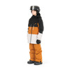 Junge in Skijacke und Hose mit Helm und Brille posiert vor weißem Hintergrund.
