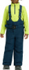 Junge in Winterkleidung, blaue Latzhose und gelber Pullover.