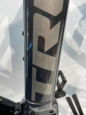 Detail eines Fahrradrahmens mit Markenlogo und leichten Kratzern. Detail eines Fahrradrahmens mit Markenlogo und leichten Kratzern.