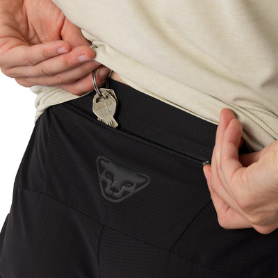 Detail von Schlüsseln, die aus einer Reißverschlusstasche einer schwarzen Hose hängen. Detail von Schlüsseln, die aus einer Reißverschlusstasche einer schwarzen Hose hängen.