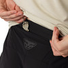 Detail von Schlüsseln, die aus einer Reißverschlusstasche einer schwarzen Hose hängen.
