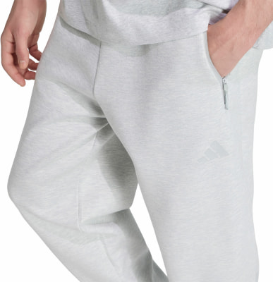 Graue Jogginghose mit Adidas-Logo und Reißverschlusstasche. Graue Jogginghose mit Adidas-Logo und Reißverschlusstasche.