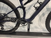 Detail der Rückseite eines dunkelblauen Mountainbikes mit Kette und Pedalen.