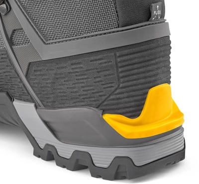 Detail eines Schuhs mit ausgeprägtem gelbem Fersenüberzug und grober Sohle. Detail eines Schuhs mit ausgeprägtem gelbem Fersenüberzug und grober Sohle.