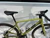 Grünes Gravelbike mit schwarzem Sattel und Lenker, Nahaufnahme.