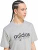 Egy férfi szürke pólóban, Adidas felirattal és koktéllal.