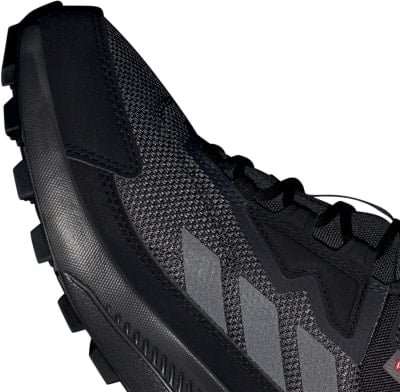 Detail černé běžecké boty s logem Adidas a podrážkou. Detail černé běžecké boty s logem Adidas a podrážkou.