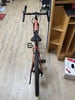Draufsicht auf ein orangefarbenes Fahrrad mit schwarzem Sattel und Lenker.