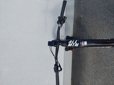 Fahrrad mit der Aufschrift ALL MTN steht an der Wand, Detail der Lenker und Kamera. Fahrrad mit der Aufschrift ALL MTN steht an der Wand, Detail der Lenker und Kamera.