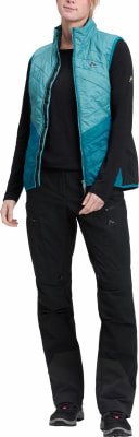 Eine Frau in einer blauen Weste und schwarzer Hose steht entspannt. Eine Frau in einer blauen Weste und schwarzer Hose steht entspannt.