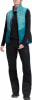 Eine Frau in einer blauen Weste und schwarzer Hose steht entspannt.