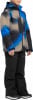 Junge in blau-beiger Kapuzenjacke und schwarzer Skihose.