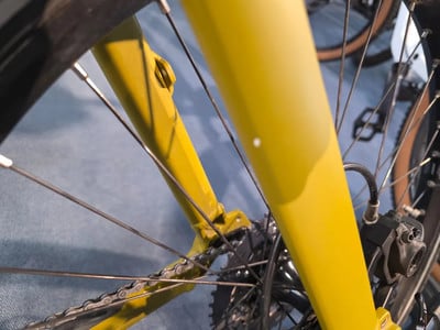 Details eines gelben Fahrradrahmens mit Kette und Speichen. Details eines gelben Fahrradrahmens mit Kette und Speichen.