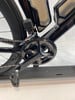 Detail des Kettenblatts und der Kurbel eines schwarzen Rennrads mit Kette.