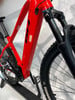 Rotes E-Bike mit schwarzen Details und Federung auf einem Ständer.