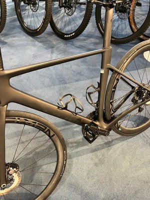 Ein schwarzer Carbon-Rennradrahmen mit Rädern und Pedalen. Ein schwarzer Carbon-Rennradrahmen mit Rädern und Pedalen.