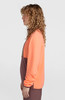 Model in einem orange-braunen Fleece-Pullover mit lockigem Haar.