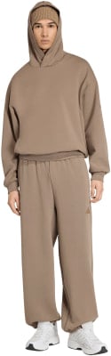 Mann in braunem Kapuzenpullover und Jogginghose mit weißen Turnschuhen. Mann in braunem Kapuzenpullover und Jogginghose mit weißen Turnschuhen.